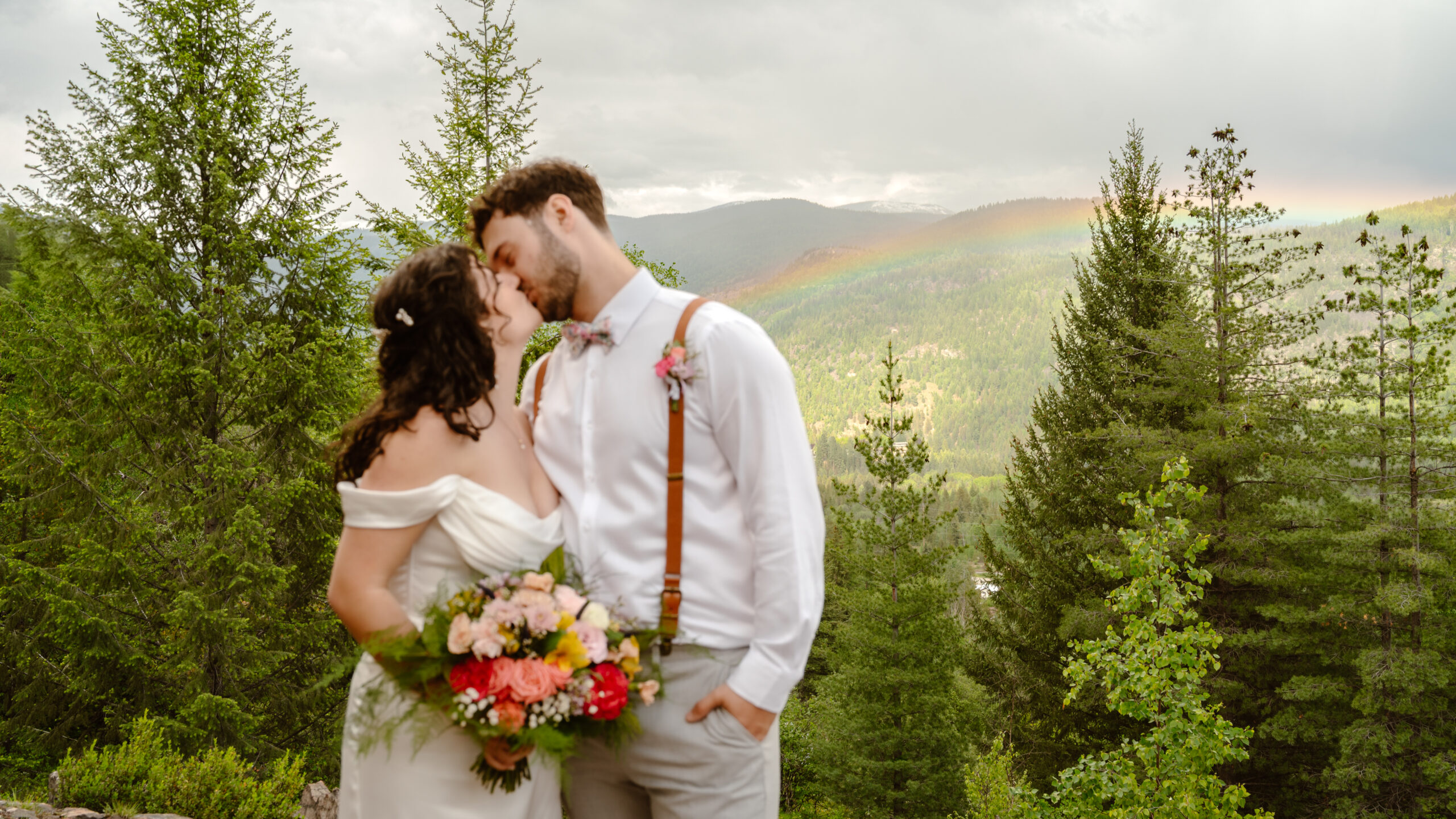 Bride and groom kissing front of a rainbow by Cranbrook wedding photographer Estelle Gonord.